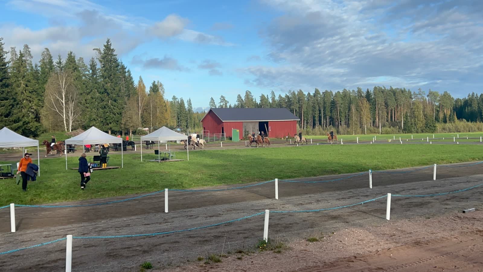 Tuomariteltat ja ratsastajia Kaakkolan baanalla kilpailujen aikaan